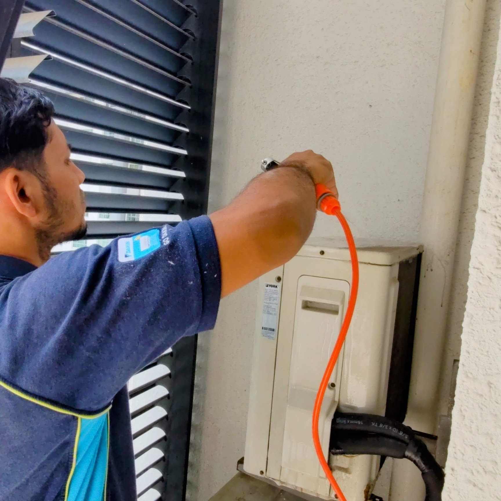 Technician checking an outdoor aircond unit